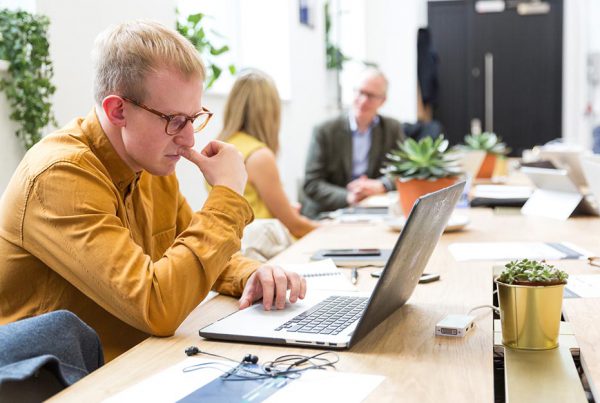 image of man looking intently at a laptop for wellspace, corporate wellness providers