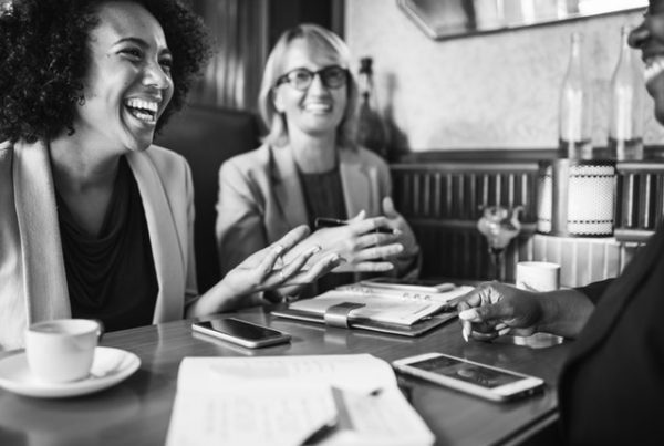 black and white image of happy colleagues with a wellness app