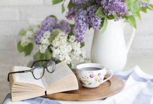 image of a book, glasses, coffee and some flowers to represent a blog from Wellspace on resilience training and managing stress