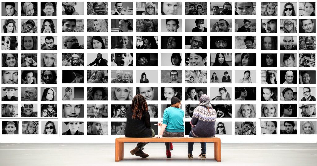 three peopel sat in front of images of people of all types for blog by Wellspace on employee mental health