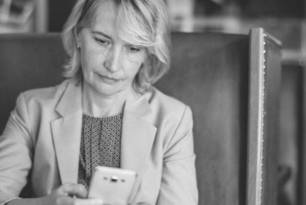 woman looking at her phone in black and white for Welspace blog