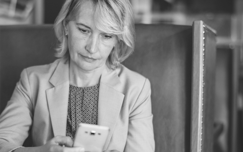 woman looking at her phone in black and white for Welspace blog