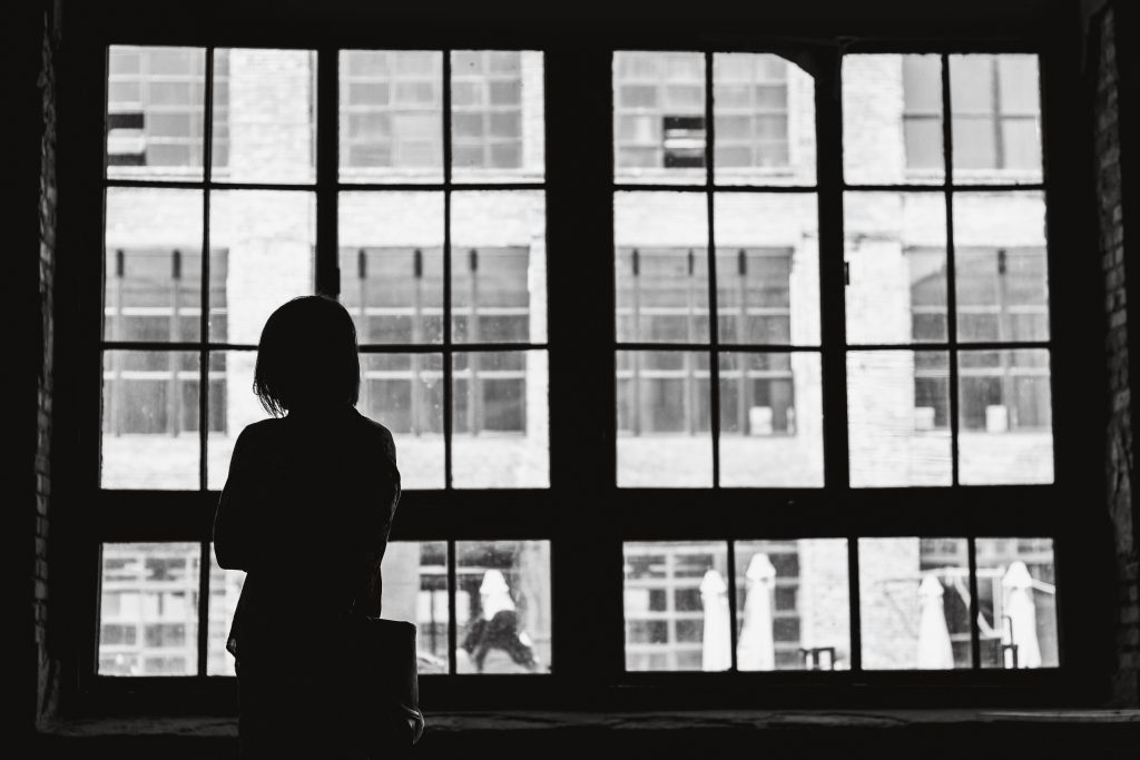 image of woman standing in front of a window for blog by wellspace on 7 signs you have an unhappy employee