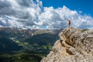 employee welless image of person standing on hilltop representing employee wellness