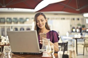 image of happy employee on her phone for employee wellbeing blog by Wellspace