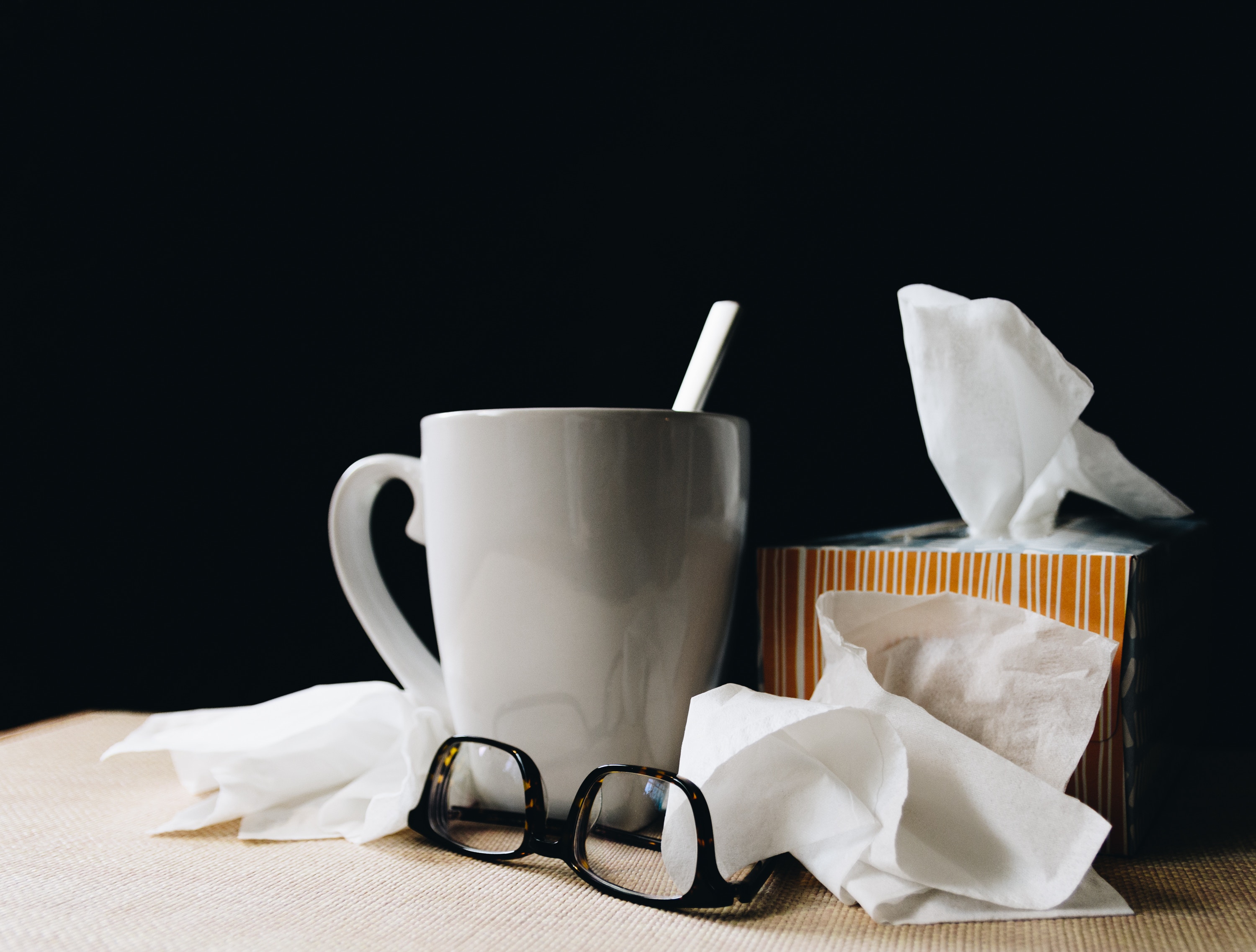 cup and tissues to represent blog by wellspace on preventing office illness