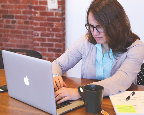 woman at laptop looking stressed for blog on handling stress in the workplace