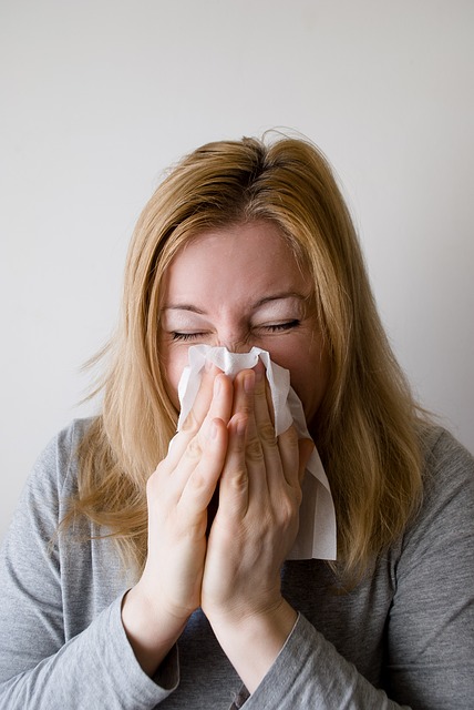 woman blowing her nose for blog by Wellspace on preventing office illness