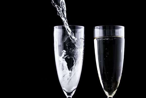 two glasses being filled with champagne for corporate wellness blog by wellspace