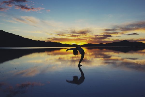 person doing yoga for corporate wellness in the sunset