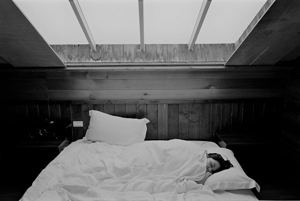 image shows a woman in bed getting a better night sleep