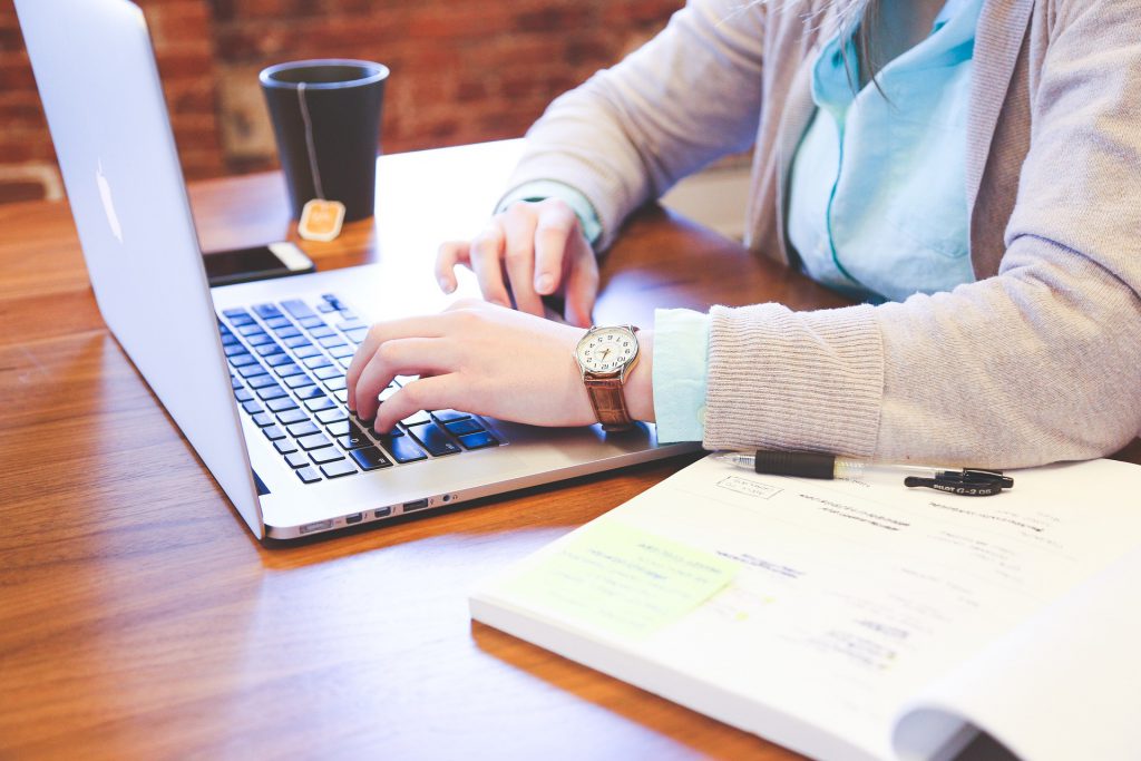 Image of employee sat at desk with laptop for Working Bank Holidays – Know Your Employee Rights blog by Wellspace