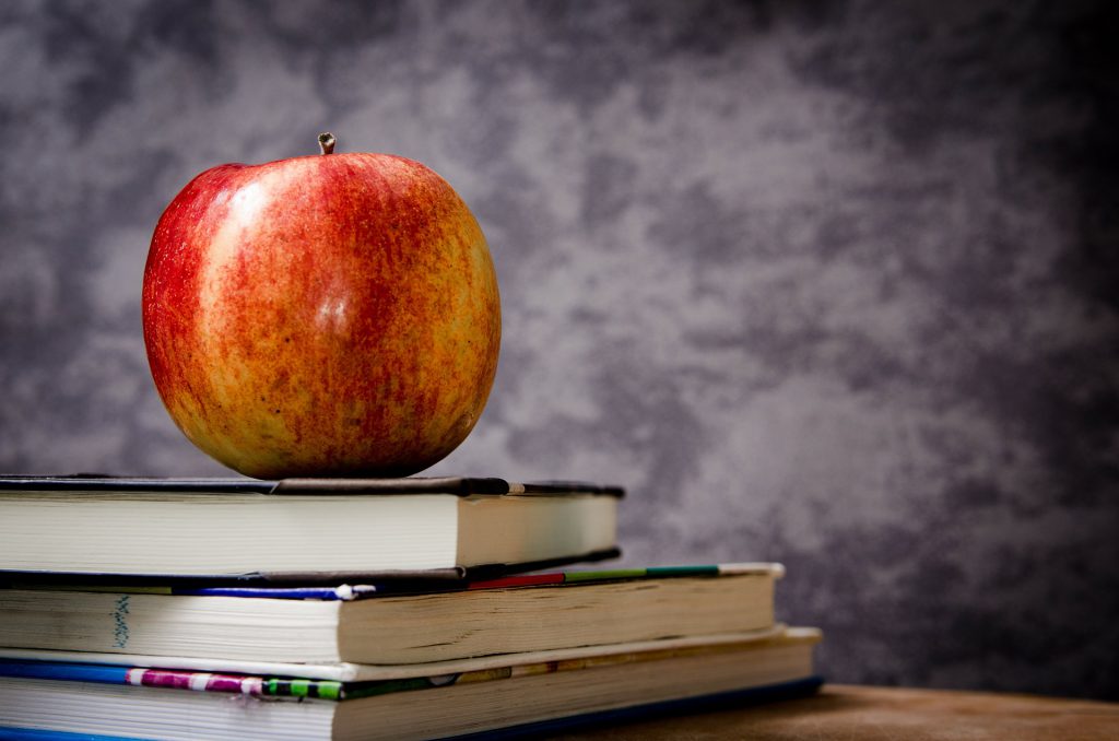 image of apple and books for blog by wellspace on workplace wellbeing and productivity 