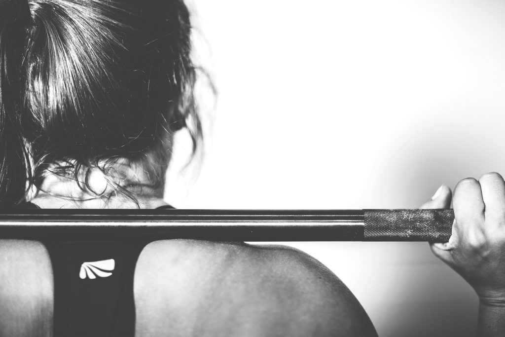 image shows a person lifting weights to represent building mental resilience