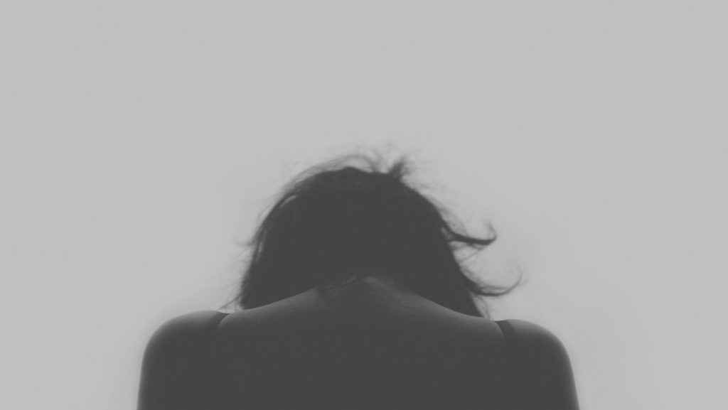 image shows a person from the back with their head lowered they may have poor mental resilience 
