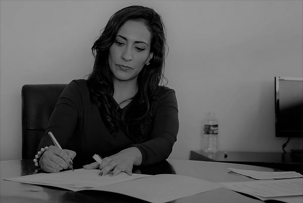 image shows a woman sat at her desk thinking about building mental resilience