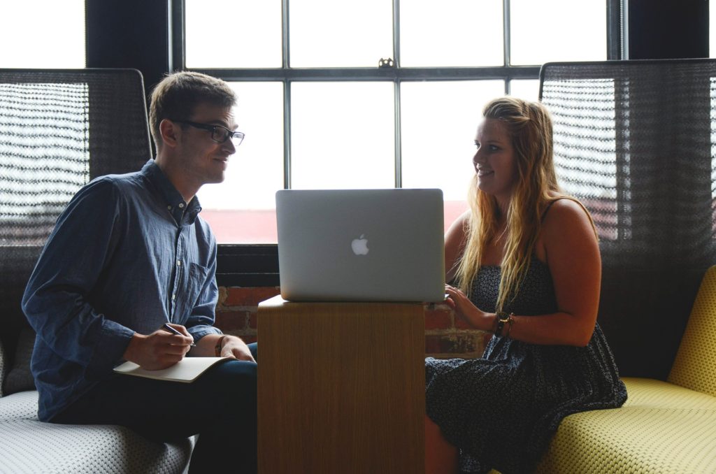 image of two young people talking at work to illustrate blog by Wellspace on Workplace Health and Wellbeing for young people
