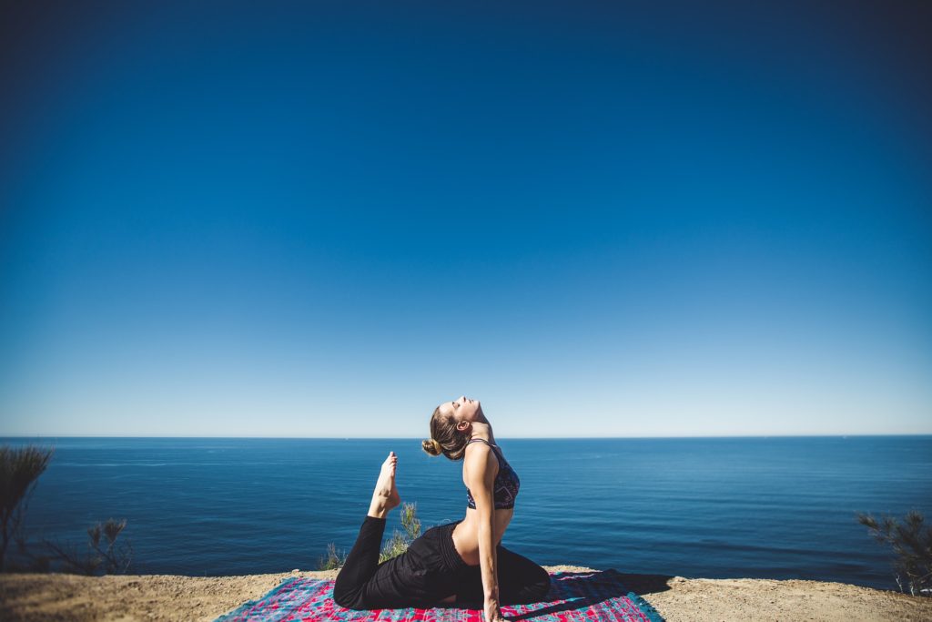 Image of woman doing yoga to depict taking a break from work for employee wellbeing