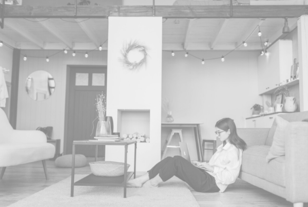 Image of a woman sitting ont he floor working from home for blog by Wellspace on Managing Employee Productivity Whilst Working from Home