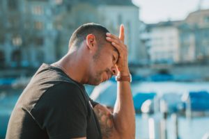 image of a man with his head in his hand for blog by wellspace on managing coronavirus stress at work