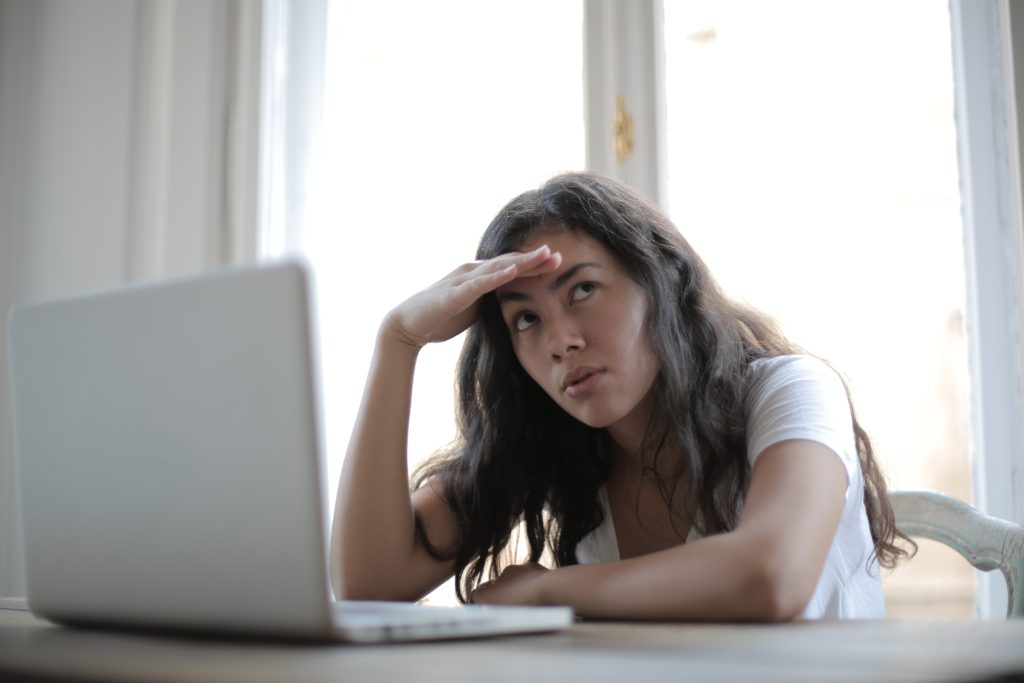 A women working from home holding her forehead with her hand as she lacks energy