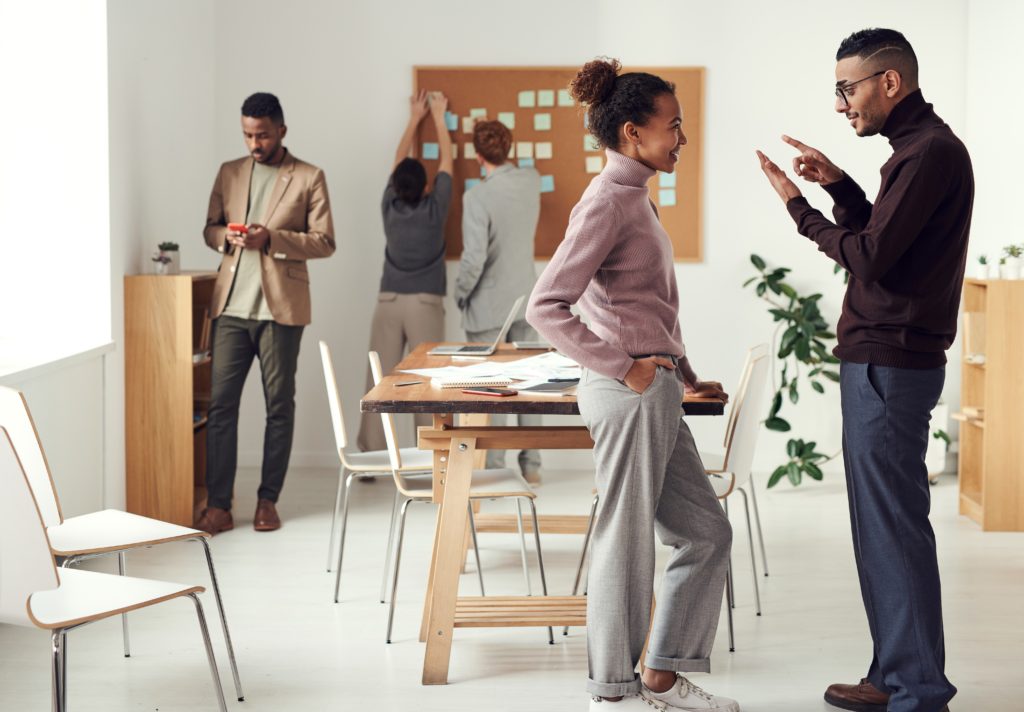 A group of colleagues talking and filling the boards with sticky notes