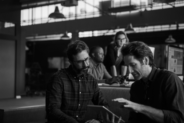 Two men at work on an iPad using a workplace app for wellness