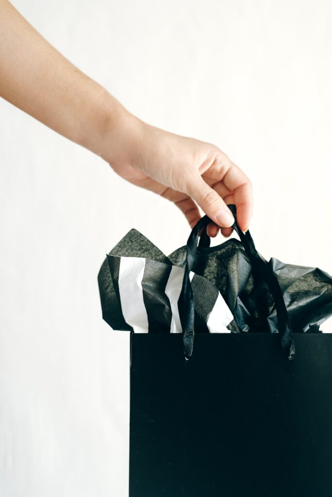 Employee reward scheme image of a black gift bag being handed over 